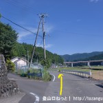 熊野萩バス停南側にある橋を渡った先でＴ字路を右折したところの分岐