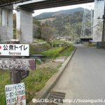 高松山の登山口に向かう途中の東名高速の高架下地点に設置されているトイレを示す案内板